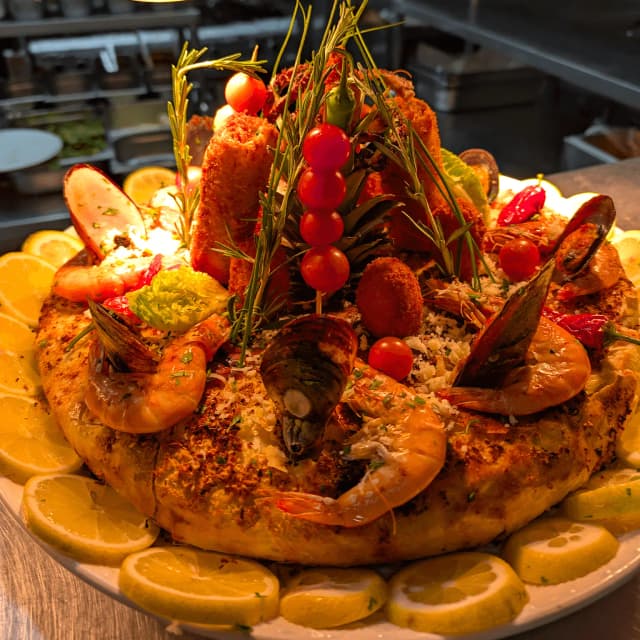 Staff iin striped shirts serving inside a food truck.